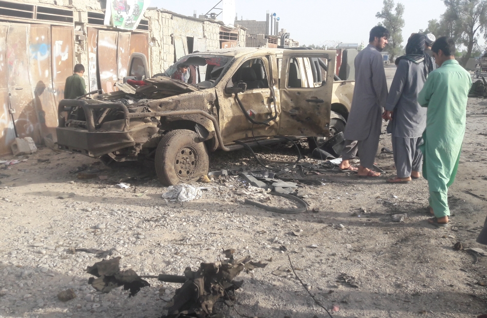 Residents look at an Army vehicle which was damaged during battle between Afghan security forces and Taliban in Farah province, Afghanistan May 16, 2018. REUTERS/Stringer