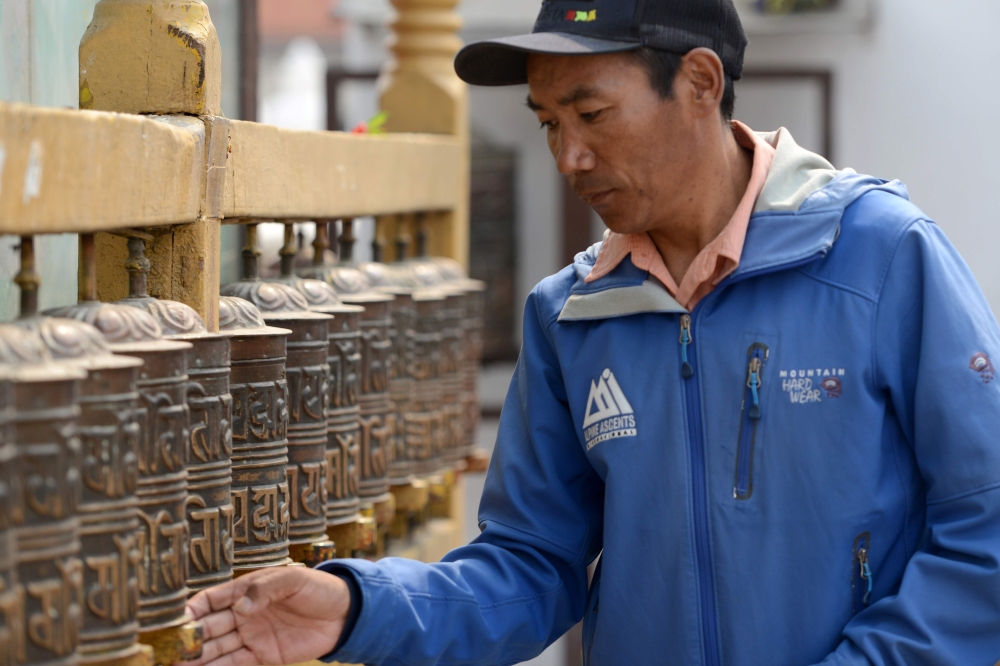 (FILES) In this photograph taken on March 28, 2018, Nepali mountaineer Kami Rita Sherpa spins prayer wheels at Boudhanath Stupa, where he has a rented room, on the outskirts of Kathmandu. XGTY / AFP / PRAKASH MATHEMA / XGTY