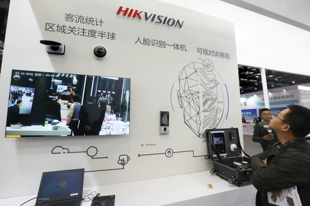 Visitors are seen at a booth of security camera supplier Hikvision Digital Technology during an expo at the National Convention Center in Beijing, China March 12, 2018. Reuters/Stringer