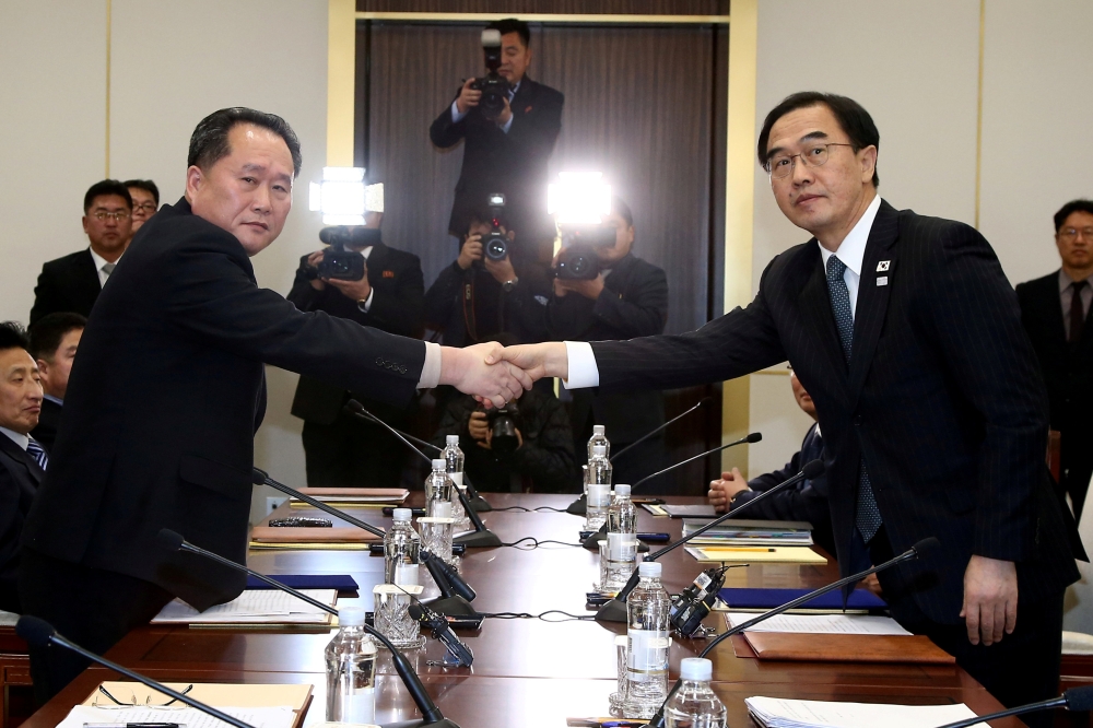 FILE PHOTO: South Korea's Unification Minister Cho Myoung-gyon shakes hands with Ri Son Gwon, chairman of North Korea's ÔCommittee for the Peaceful Reunification of the country', as they exchange documents after their meeting at the truce village of Panmu