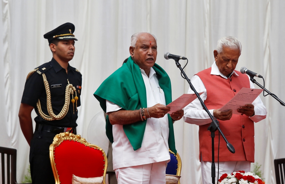 India's ruling Bharatiya Janata Party (BJP) leader B. S. Yeddyurappa is administered the oath as Chief Minister of the southern state of Karnataka by Governor Vajubhai Vala inside the Governor's house in Bengaluru, India, May 17, 2018. Reuters/Abhishek N.