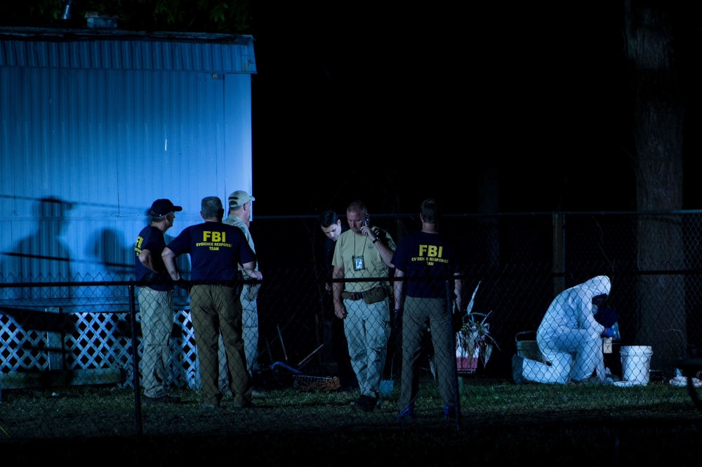 Investigators work outside a trailer near Santa Fe High School following a mass shooting May 18, 2018 in Santa Fe, Texas. / AFP / Brendan Smialowski 