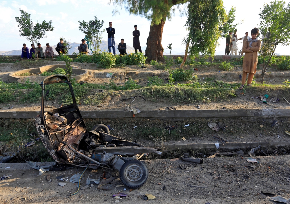 People look at a damaged auto rickshaw after blasts in Jalalabad city, Afghanistan May 19, 2018. REUTERS/Parwiz