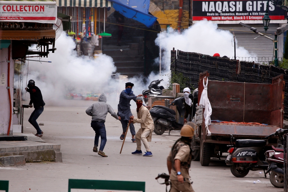 Demonstrators hurl stones towards Indian police, during a protest against the recent killings of Palestinian protesters on the Gaza-Israel border and the U.S. embassy move to Jerusalem, in Srinagar, May 18, 2018. REUTERS/Danish Ismail