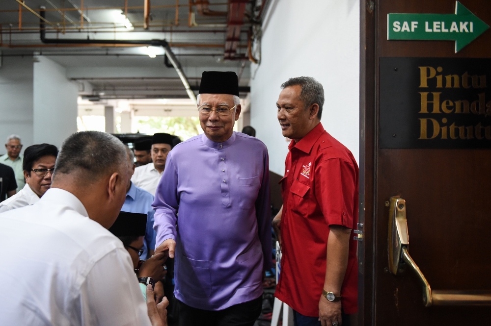 Malaysia's former prime minister Najib Razak (C) arrives for Friday prayers at the Barisan Nasional party headquarters in Kuala Lumpur on May 18, 2018. / AFP / Mohd RASFAN 