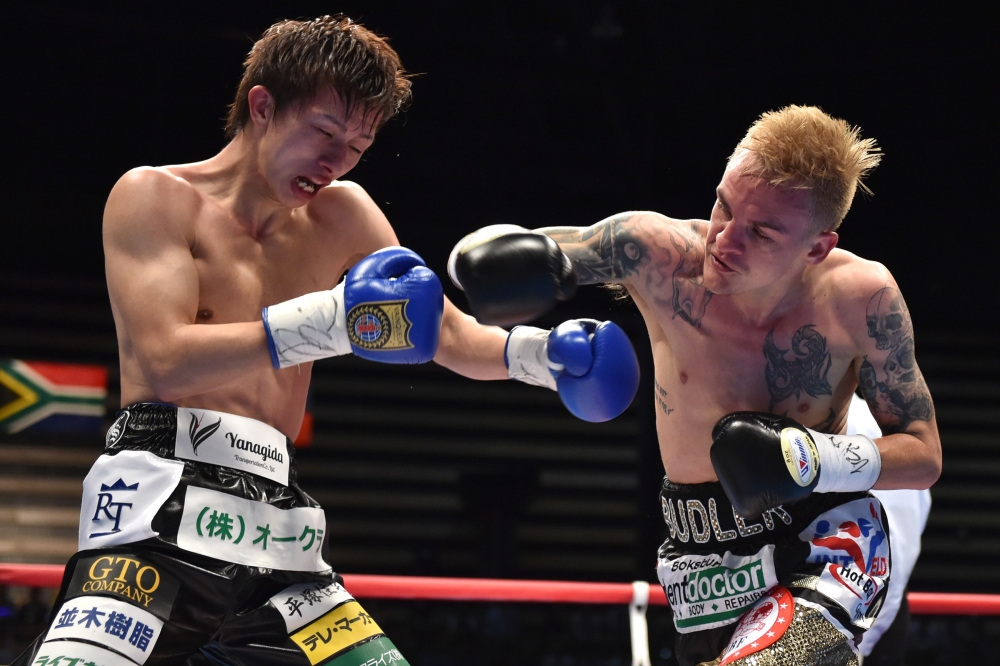 :South Africa's Hekkie Budler (R) punches Japan's Ryoichi Taguchi during their IBF, WBA world light flyweight unification title boxing bout in Tokyo on May 20, 2018. / AFP / Kazuhiro NOGI 