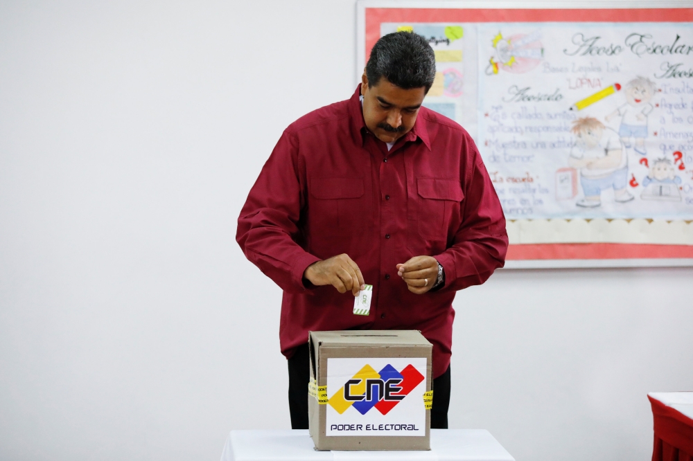 :Venezuela's President Nicolas Maduro casts his vote at a polling station, during the presidential election in Caracas, Venezuela May 20, 2018. REUTERS/Carlos Garcia Rawlins
