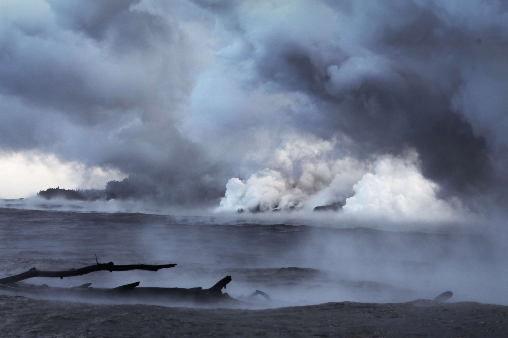 A steam plume rises as lava enters the Pacific Ocean, after flowing to the water from a Kilauea volcano fissure, on Hawaii's Big Island on May 20, 2018 near Pahoa, Hawaii.  Mario Tama/Getty Images/AFP 