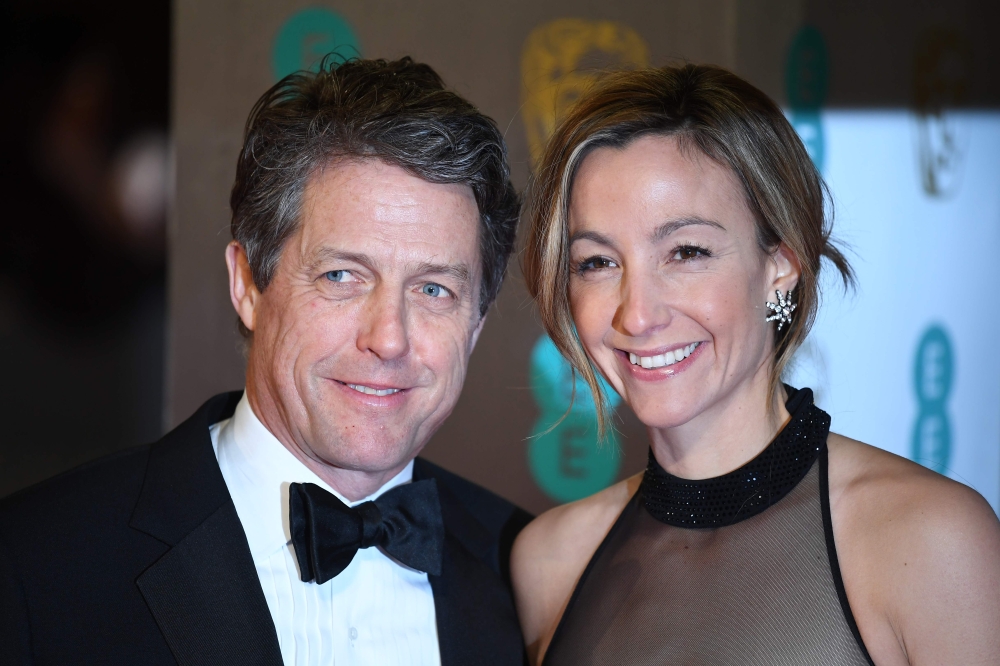 (FILES) In this file photo taken on February 12, 2017, British actor Hugh Grant (L) and Swedish producer Anna Eberstein (R) pose upon arrival at the BAFTA British Academy Film Awards at the Royal Albert Hall in London on February 12, 2017. AFP / Justin TA