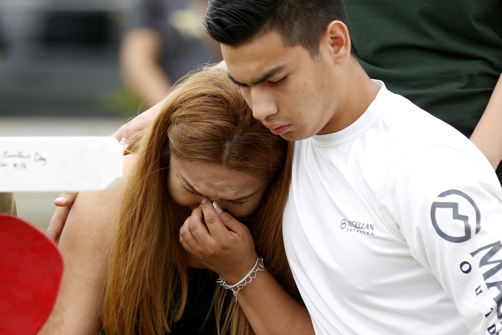 Mourners pray at a makeshift memorial left in memory of the victims killed in a shooting at Santa Fe High School in Santa Fe, Texas, U.S., May 21, 2018. Reuters/Jonathan Bachman