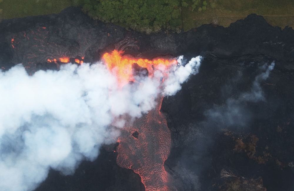 Lava erupts and flows from a Kilauea volcano fissure, towards the Pacific Ocean, on Hawaii's Big Island on May 21, 2018 near Pahoa, Hawaii.  Mario Tama/Getty Images/AFP