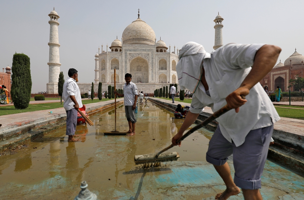 Labourers clean the fountain in the historic Taj Mahal premises in Agra, India, May 19, 2018. Reuters/Saumya Khandelwal