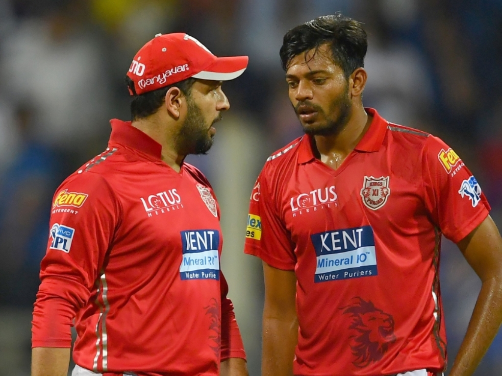 Kings XI Punjab cricketer Yuvraj Singh (L) talks with teammate Ankit Rajpoot after he was hit for runs during the 2018 Indian Premier League (IPL) Twenty20 cricket match between Mumbai Indians and Kings XI Punjab at the Wankhede Stadium in Mumbai on May 1