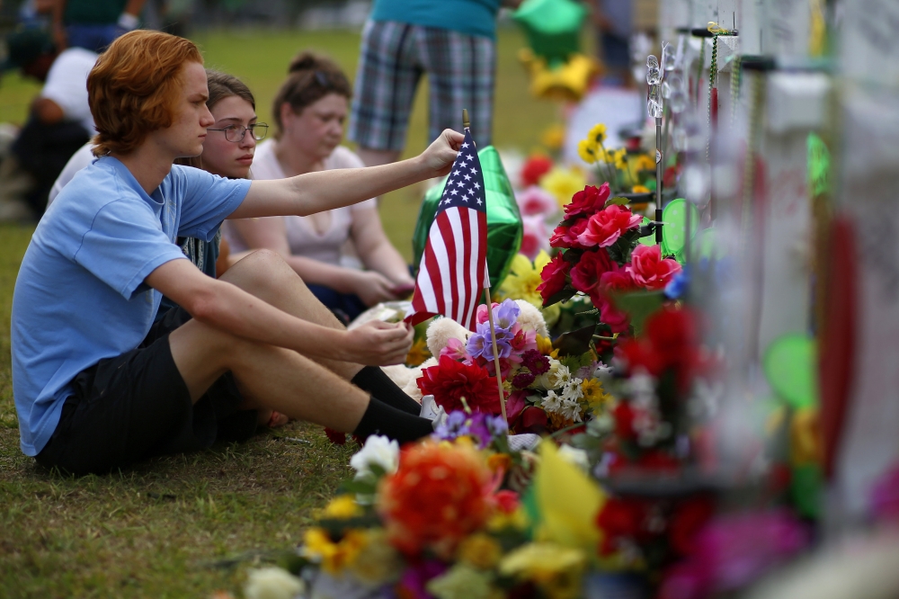 Mourners gather at a makeshift memorial left in memory of the victims killed in a shooting at Santa Fe High School in Santa Fe, Texas, U.S., May 21, 2018. REUTERS/Jonathan Bachman