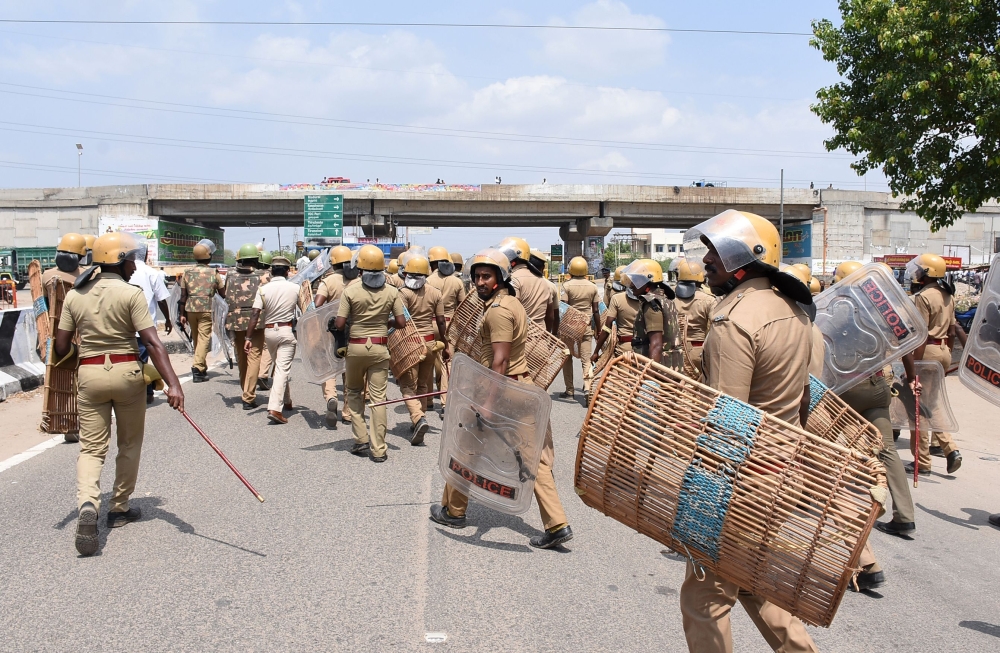 Indian police officials run towards protestors in the southern Indian city of Tuticorin some 600 kilometres (375 miles) south of Chennai on May 22, 2018, during a protest rally held to demand the closure of a copper factory due to pollution concerns. AFP 