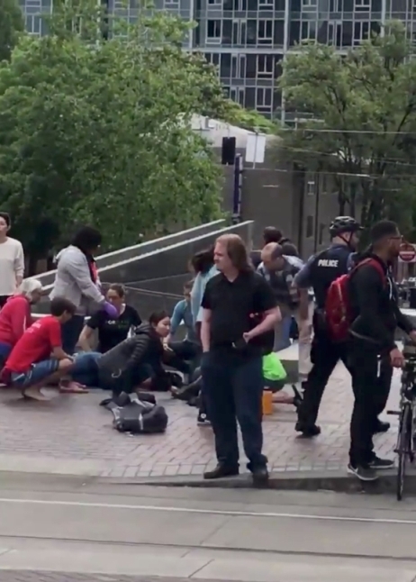 Police officer is seen among pedestrians after a hit-and-run incident at Portland State University, in Portland, Oregon, U.S., May 25, 2018 in this still image obtained from social media video. MATTHEW RITZI/via REUTERS 