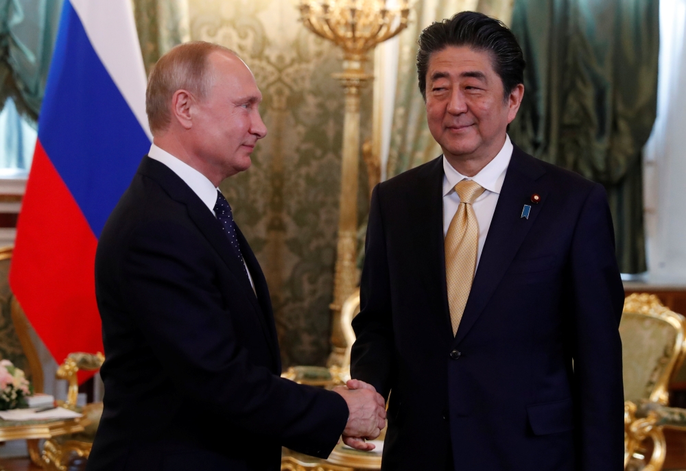 Russian President Vladimir Putin shakes hands with Japanese Prime Minister Shinzo Abe during their meeting at the Kremlin in Moscow, Russia May 26, 2018. REUTERS/Grigory Dukor