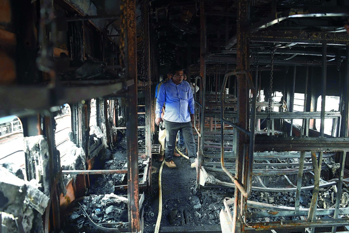 In a separate incident, Railway officials and policemen inspect a damaged carriages after a fire incident took place in a long distance train parked at the yard of Chatrapati Shivaji Terminal (CST), in Mumbai on May 29, 2018. AFP / Punit Paranjpe