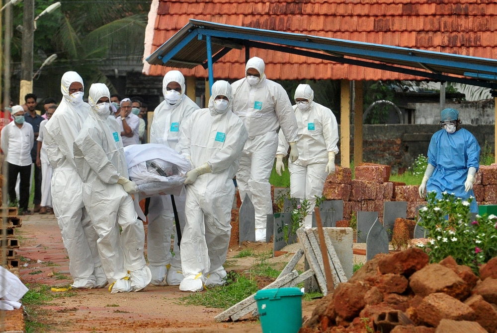 Doctors and relatives wearing protective gear dig a grave to bury a victim of the brain-damaging Nipah virus in Kozhikode, Kerala, India, May 24, 2018. Reuters/Stringer