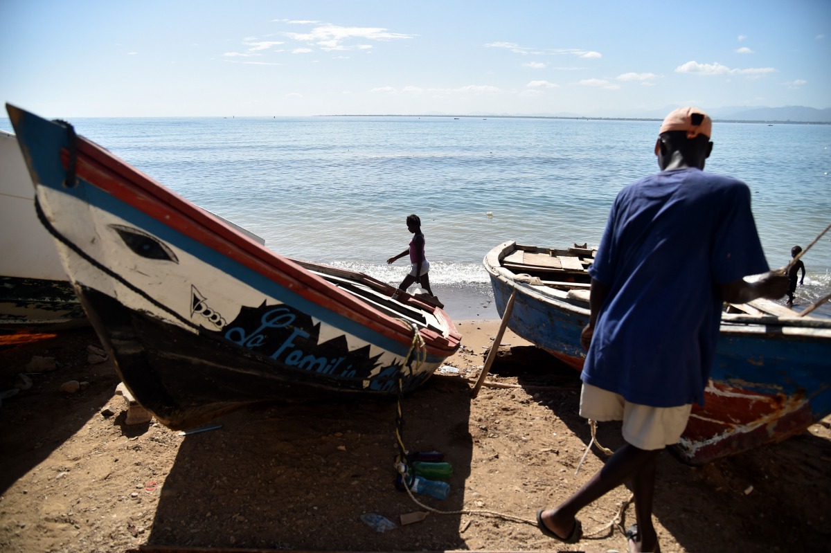 A fisherman works next to a boat in Cap-Haitien, Haiti on September 6, 2017 ,240kms north of Port-au-Prince (AFP / Hector Retamal) 