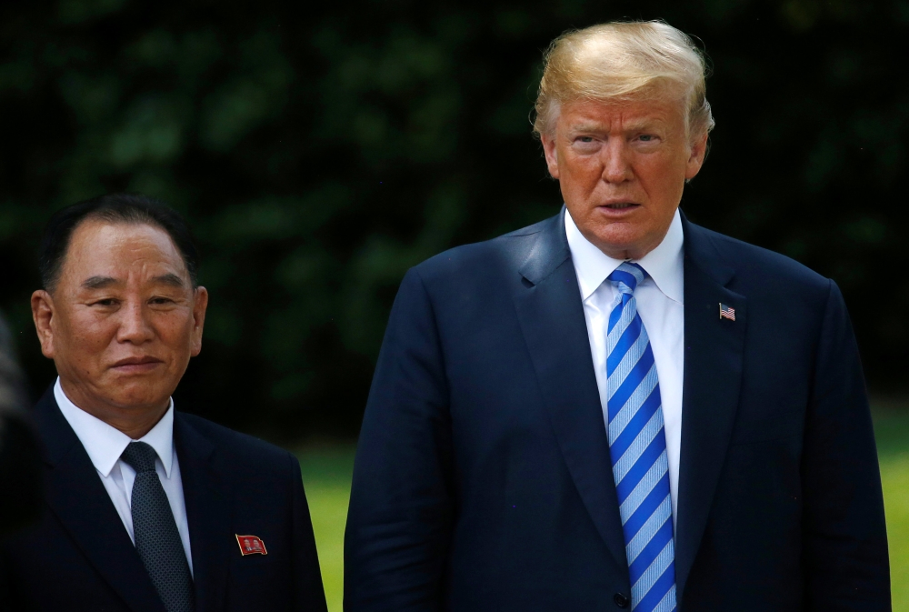 North Korea's envoy Kim Yong Chol poses with U.S. President Donald Trump for a photo by an official photographer as he departs after a meeting at the White House in Washington, U.S., June 1, 2018. REUTERS/Leah Millis