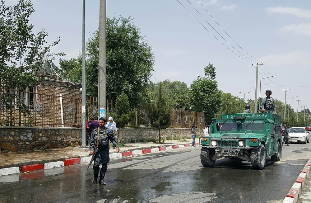 Afghan policemen stand guard near the site of a suicide attack at the gates of Kabul's Polytechnic University in Kabul on June 4, 2018. AFP / Ahmad Zafar 