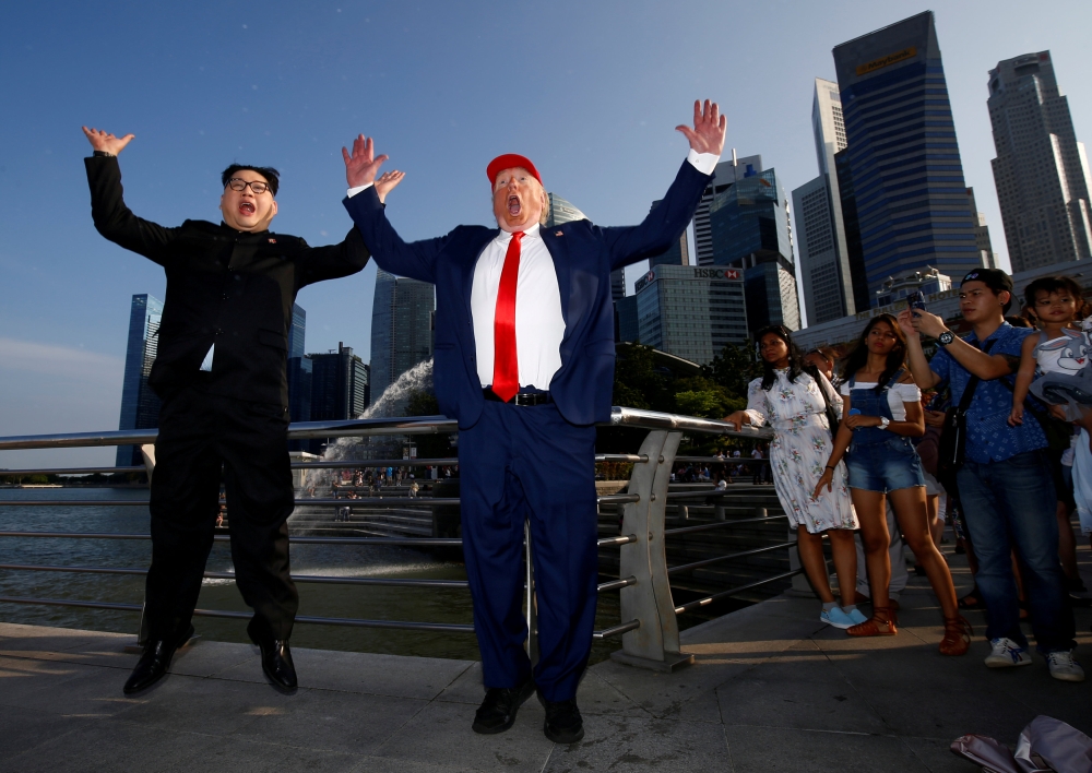 Howard, an Australian-Chinese impersonating North Korean leader Kim Jong-un, and Dennis Alan, impersonating U.S. President Donald Trump, meet at Merlion Park in Singapore June 8, 2018. REUTERS/Edgar Su