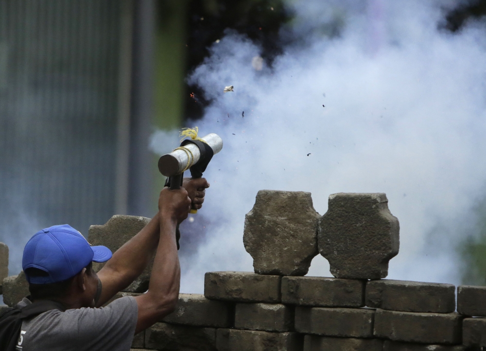 An anti-government demonstrator fires a home-made mortar during clashes with riot police at a barricade in the town of Masaya, 35 km from Managua on June 9, 2018. AFP / INTI OCON