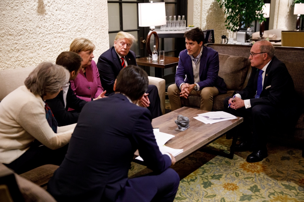 Canada's Prime Minister Justin Trudeau and G7 leaders France's President Emmanuel Macron, Germany's Chancellor Angela Merkel, Britain's Prime Minister Theresa May and U.S. President Donald Trump hold a meeting with staff on the first day of the G7 meeting