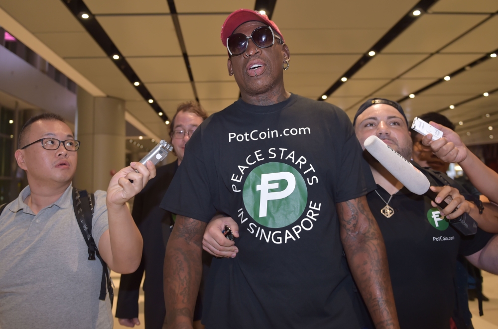 Retired American professional basketball player Dennis Rodman speaks to the press as he arrives at Changi International airport ahead of US-North Korea summit in Singapore on June 11, 2018. AFP / ADEK BERRY

