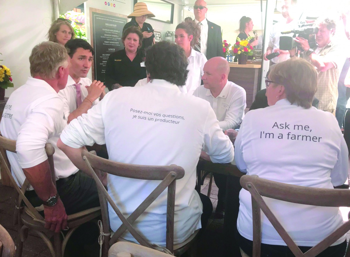 Canadian Prime Minister Justin Trudeau (2L) speaks with dairy farmers in Ottawa, Ontario on June 12, 2018.  AFP / Michel Comte

