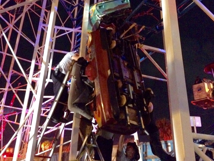 Daytona Beach firefighters are working to rescue two roller coaster riders that are in a dangling rollercoaster car when their car derailed on the Daytona Beach, Florida, boardwalk on June 14, 2018 in this Daytona Beach Fire Department photo. (Courtesy Da