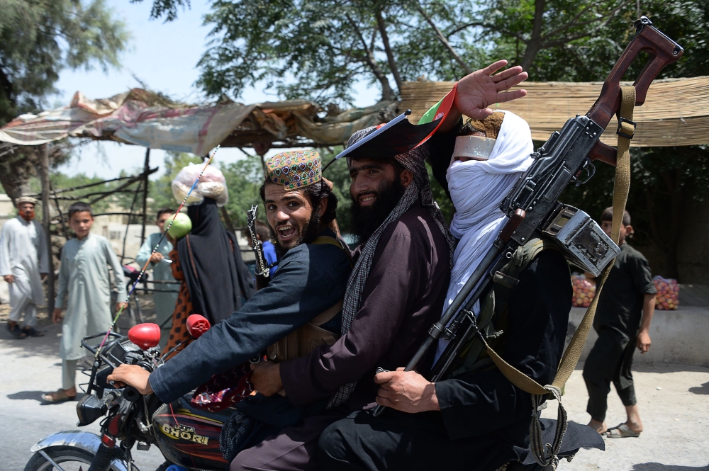 Afghan Taliban militants ride a motorbike as they took to the street to celebrate ceasefire on the second day of Eid in the outskirts of Jalalabad on June 16, 2018. (AFP / NOORULLAH SHIRZADA)