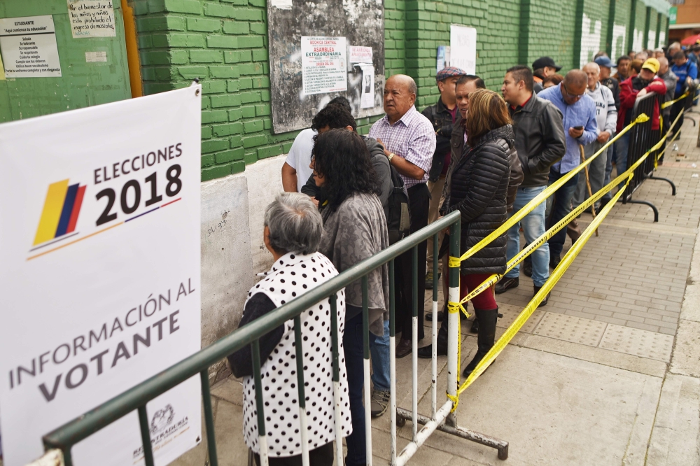 People queue to vote at a polling station during the second round of the presidential elections in Bogota, Colombia on June 17, 2018 Colombians choose a new president Sunday in a landmark election, the first since a peace agreement with FARC rebels which 