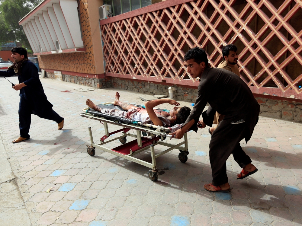 An injured man is pushed on a stretcher to a hospital after a car bomb in Jalalabad city, Afghanistan on June 17, 2018. REUTERS/Parwiz