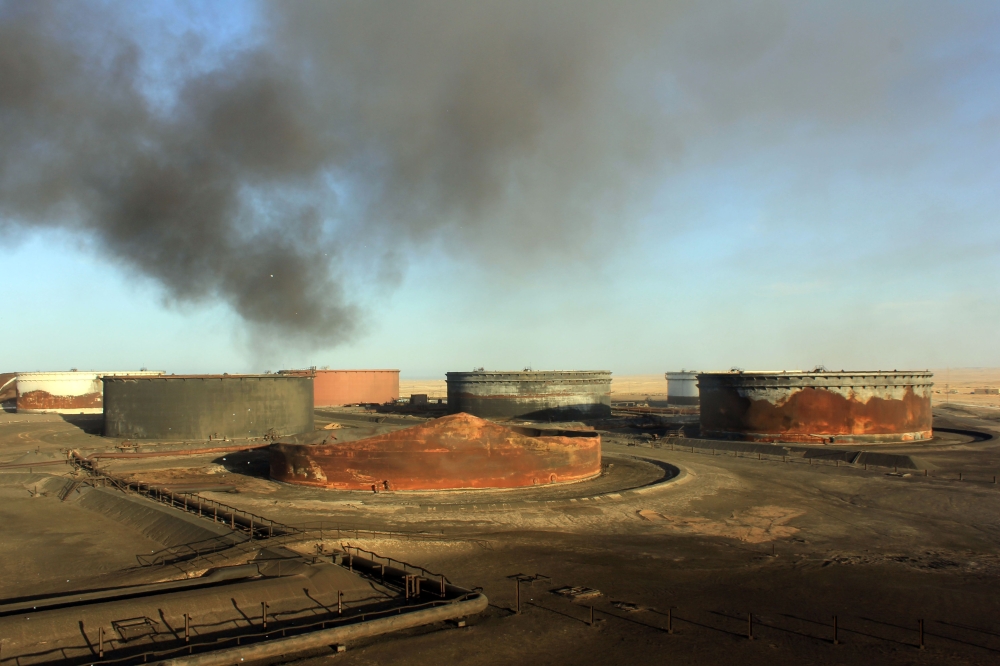 A file photo taken on January 08, 2016 shows smoke billowing from a petroleum storage tank after a fire was extinguished at Al-Sidra oil terminal, near Ras Lanuf in the so-called 
