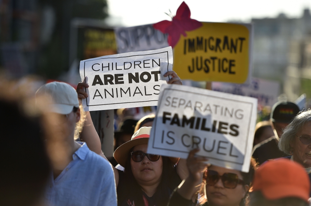 (FILES) In this file photo taken on June 14, 2018, critics of US government policy which separates children their parents when they cross the border illegally from Mexico protest during a 'Families Belong Together March', in downtown Los Angeles, Californ