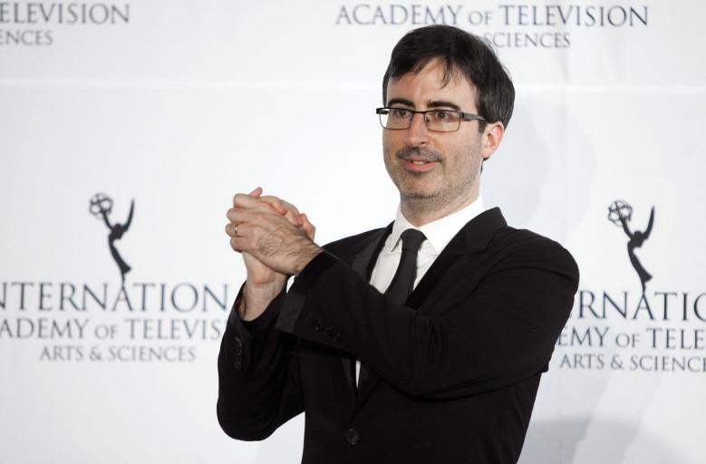 File photo of comedian John Oliver posing for photographers backstage during the 41st International Emmy Awards in New York, November 25, 2013. REUTERS/Carlo Allegri