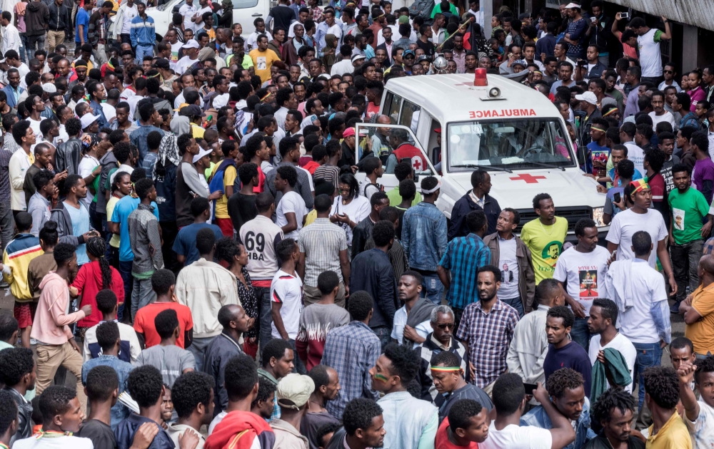 Ethiopians gather around an ambulance in Meskel Square in Addis Ababa on June 23, 2018, after an attack on a rally called by the Prime Minister Abiy Ahmed. AFP / YONAS TADESE