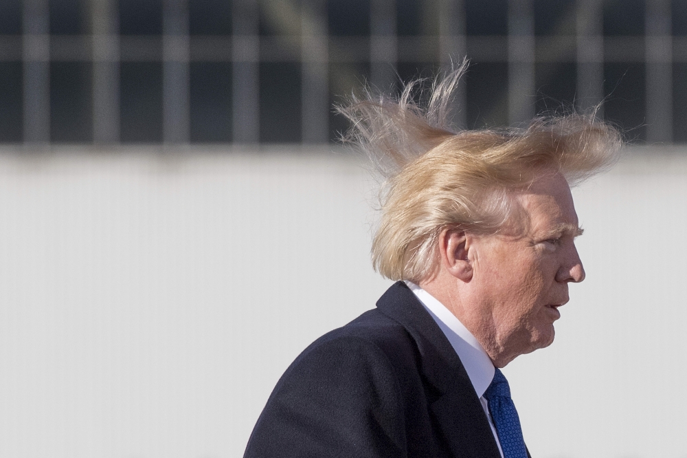 (FILES) In this file photo taken on November 10, 2017, US President Donald Trump's hair blows in the wind as he boards Air Force One before flying to Vietnam to attend the annual Asia Pacific Economic Cooperation (APEC) summit at Beijing airport. AFP / Ji