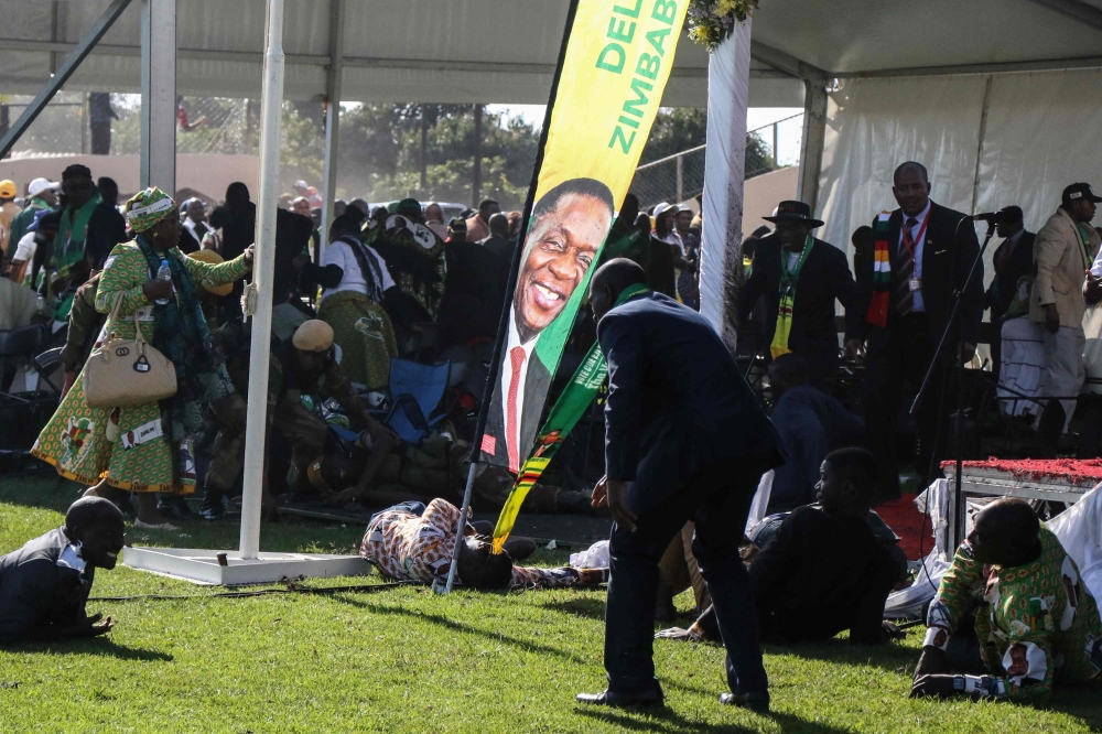 Injured people lie on the ground after an explosion at the stadium in Bulawayo where Zimbabwe President just addressed a rally on June 23, 2018. AFP / KEN MAUR / DO NOT USE ON TWITTER
