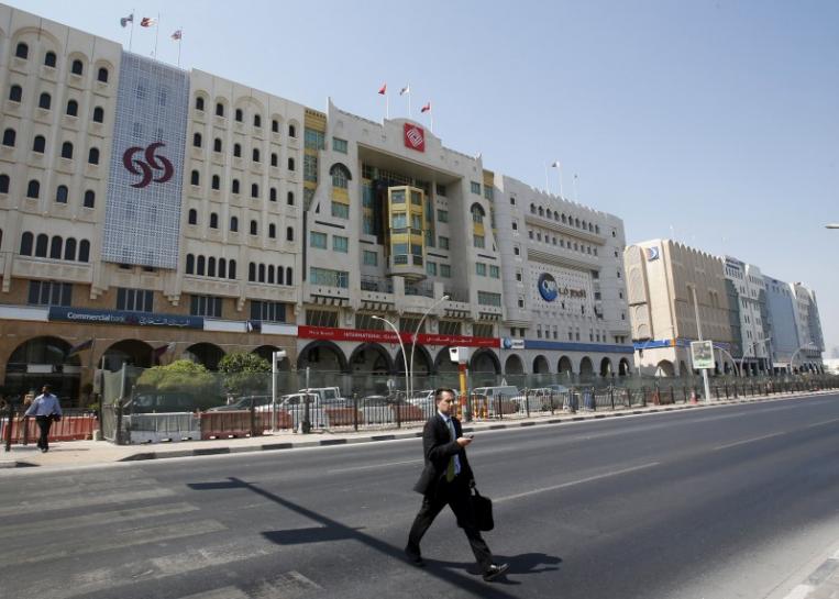 A man crosses Grand Hamad street where banks and financial institutions are located in Doha (Reuters)