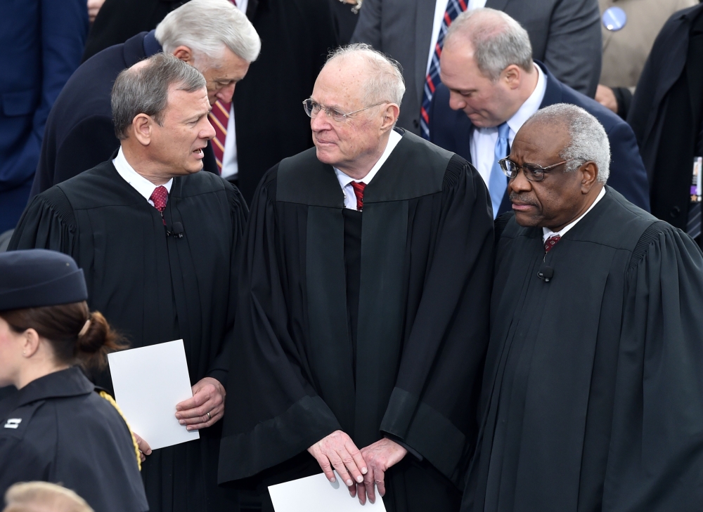 (FILES) In this file photo taken on January 20, 2017 L-R: US Chief Justice John Roberts, Justice Anthony Kennedy and Justice Clarence Thomas stand on the platform of the US Capitol in Washington, DC, before the swearing-in ceremony of US President-elect D