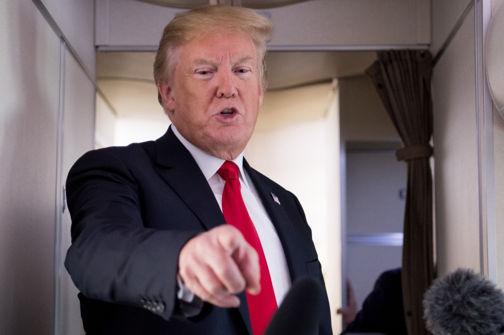 US President Donald Trump speaks to the press aboard Air Force One in flight as he travels from Joint Base Andrews in Maryland, to Bedminster, New Jersey, June 29, 2018. / AFP / SAUL LOEB
