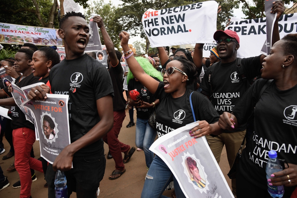 Protesters shout slogans and hold banners reading 