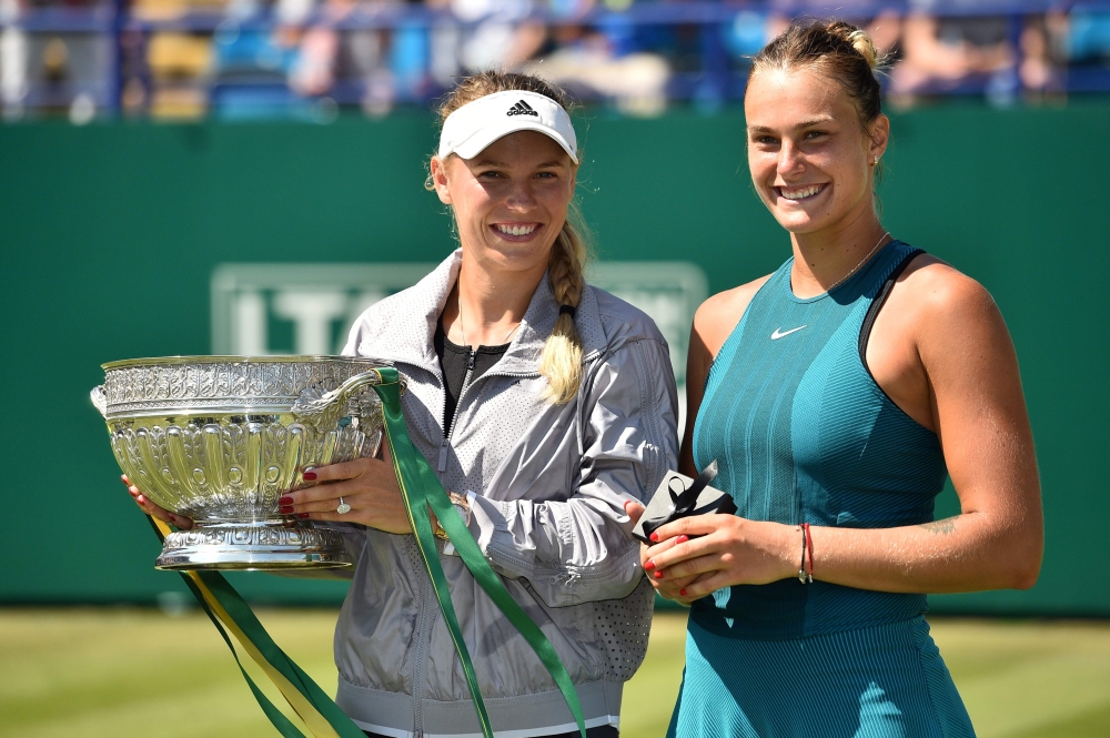 Denmark's Caroline Wozniacki holds the winner's trophy (L) alongside Belarus's Aryna Sabalenk aafter their Women's singles finals match at the ATP Nature Valley International tennis tournament in Eastbourne, southern England on June 30, 2018.  AFP / Glyn 