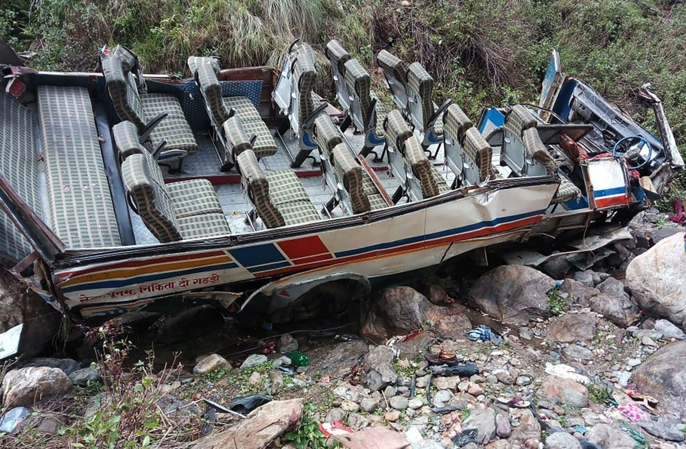 This handout photo taken and released on July 1, 2018 by the State Disater Response Found (SDRF), shows a wrecked bus and passengers belongings scattered after the bus fell into a gorge in the hilly Pauri Garhwal district in the northen state of Uttarakha