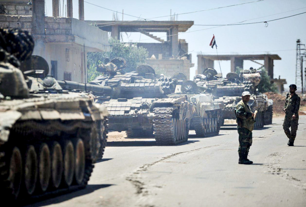 Syrian government tanks and soldiers taking position in the town of Western Ghariyah, about 15 kilometres east of the southern embattled city of Daraa. / AFP / SANA