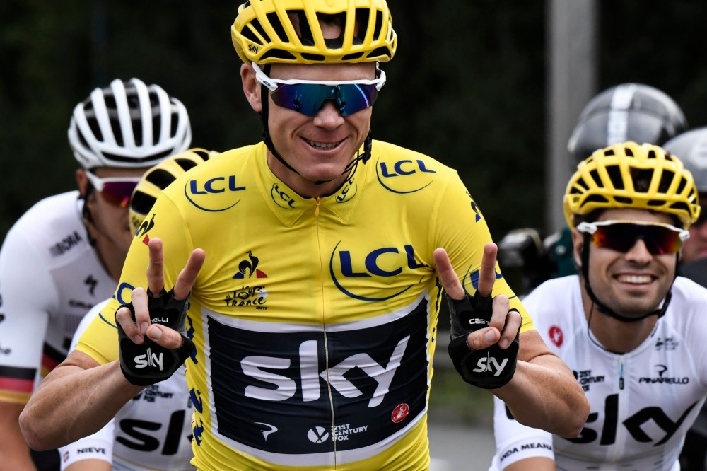 File photo of Great Britain's Christopher Froome (C) wearing the overall leader's yellow jersey flashing victory sign during the 103 km twenty-first and last stage of the 104th edition of the Tour de France cycling race, July 23, 2017. / AFP / Jeff PACHOU
