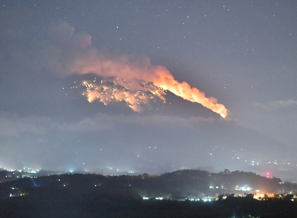 Mount Agung volcano erupts during the night, as seen from Bugbug village in Karangasem regency in Bali, Indonesia, July 2, 2018. Picture taken July 2, 2018. Andre Ardiansyah/Handout via REUTERS